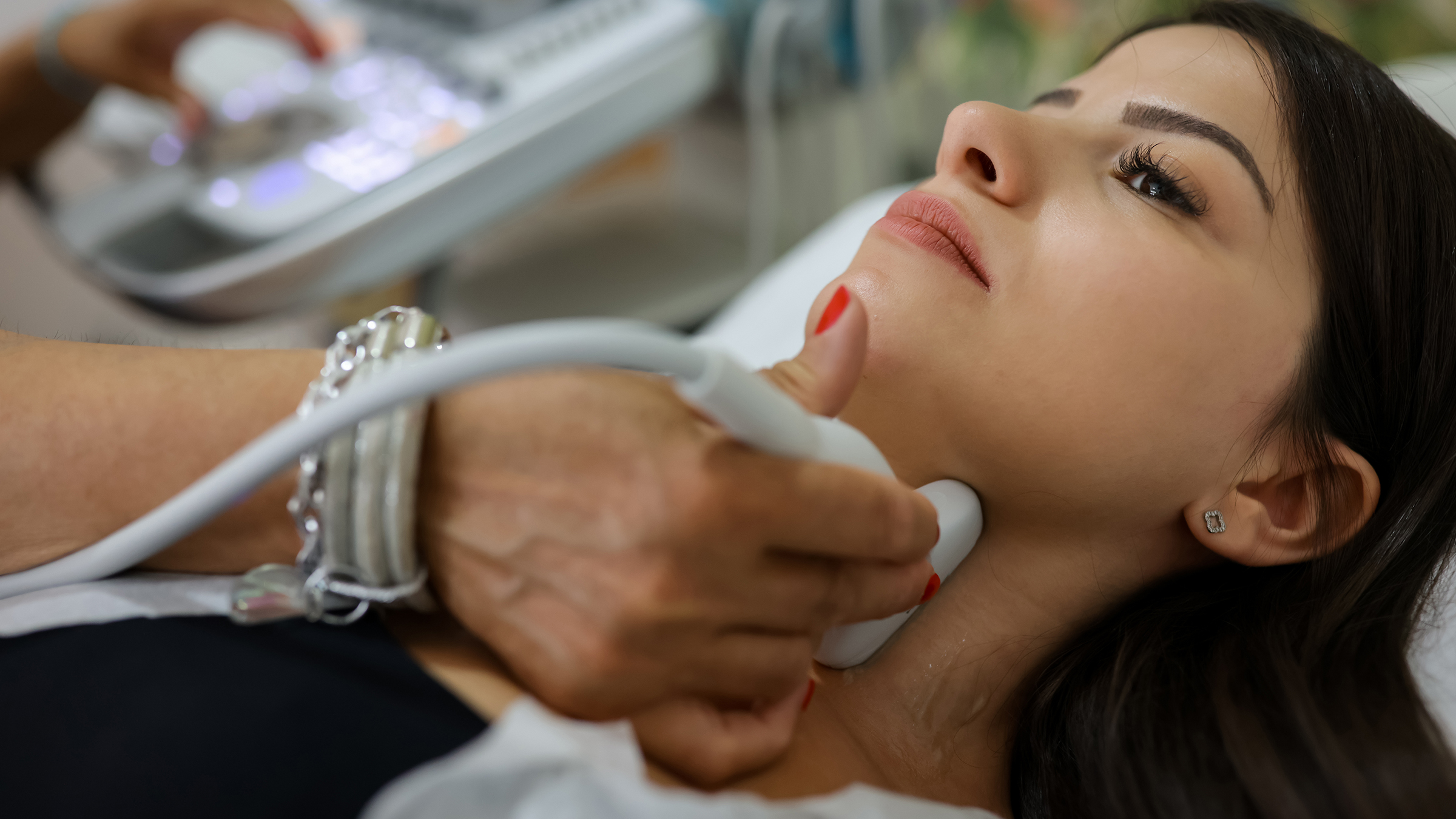 Close up shot of young woman getting her neck examined by doctor using ultrasound scanner